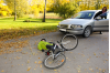 Den här pojken har krockat med en bil och slagit sig ordentligt. Som tur är hade han hjälm. Det ska man alltid ha när man cyklar. Pojke har krockat med bil och ligger på marken med cykel bredvid sig.