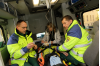 I bilen kollar ambulanspersonalen hela tiden att pojken mår så bra som möjligt. Pojken ligger i ambulansen och personalen sitter brevid.