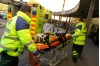 När ambulansen är framme vid barnsjukhuset tar ambulanspersonalen pojken till barnakuten. Ambulanspersonalen drar pojken från ambulansen in till barnakuten.